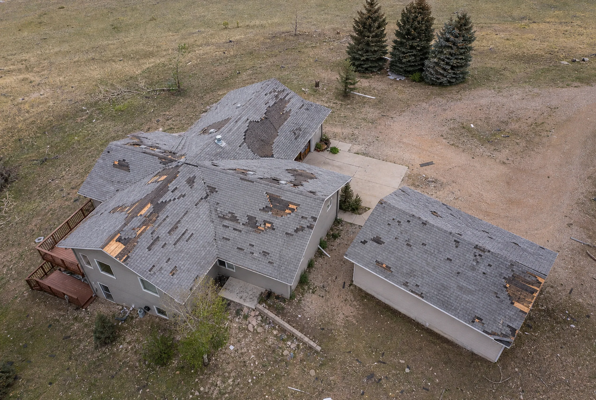Storm-damaged roof and outbuilding documented from the air after a hail event
